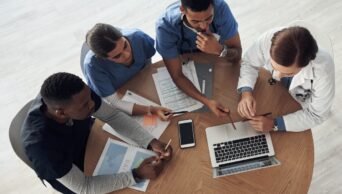 Grupo ao redor de papeis de notebook